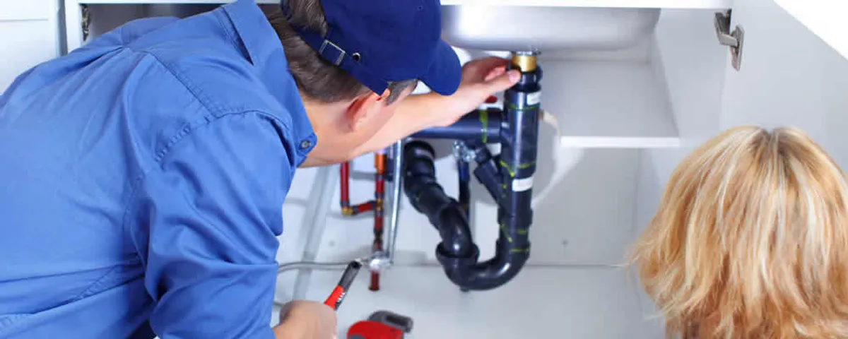 Plumber repairing under-sink drain pipes and fittings in Naperville, IL